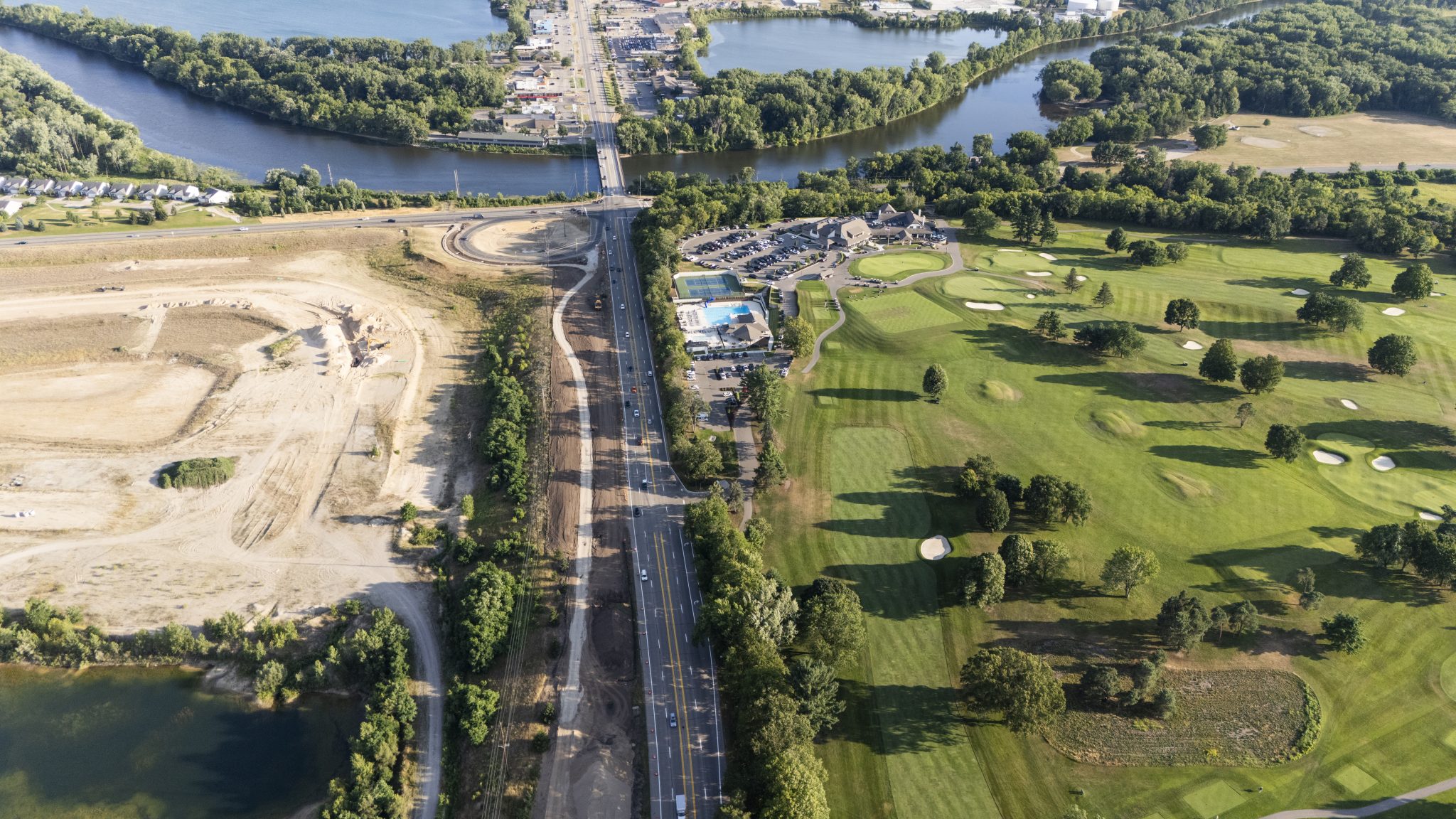 Aerial view of a new trail being built along a road nearby a river