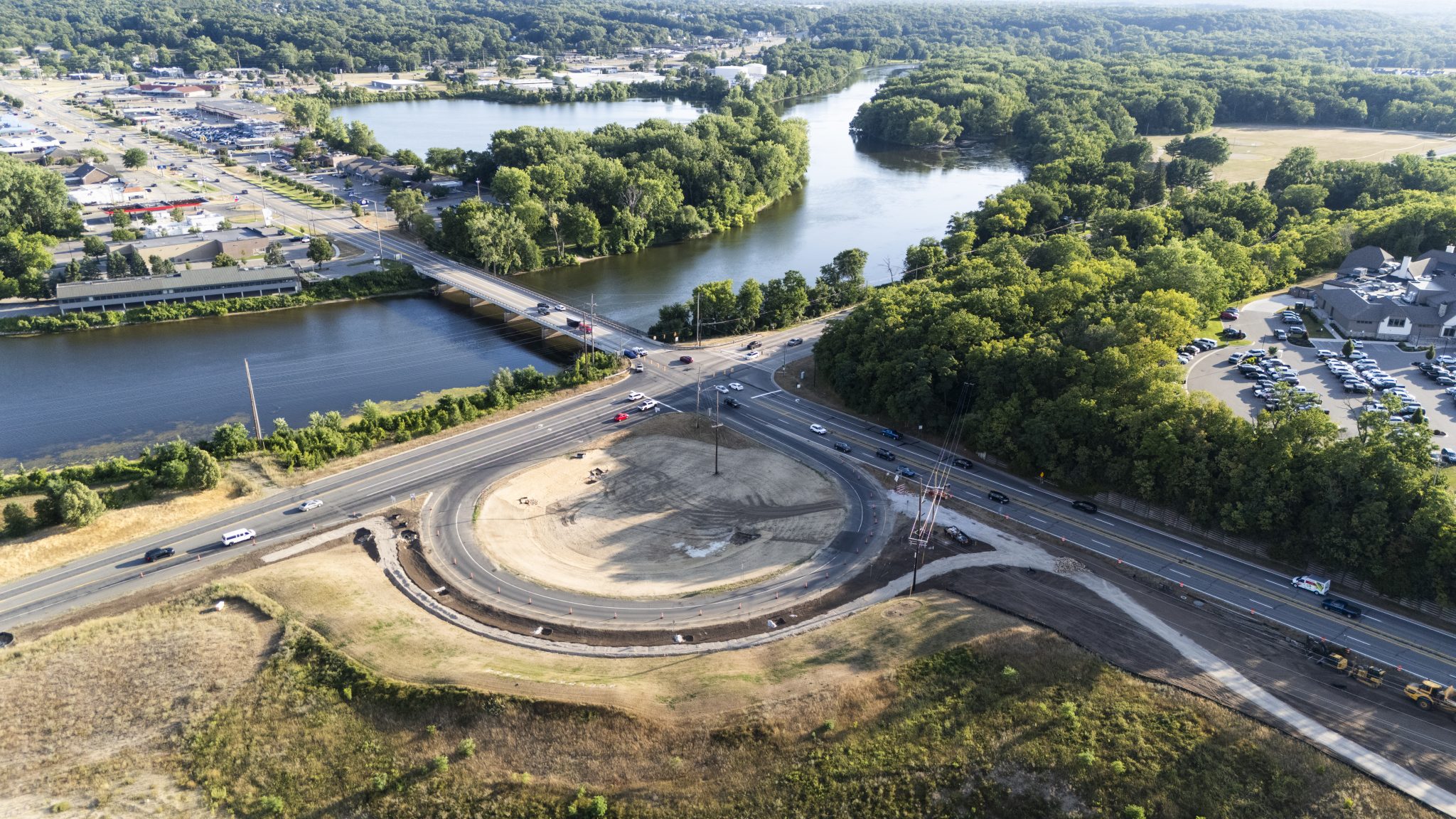 Aerial view of trail construction along a river and a busy intersection