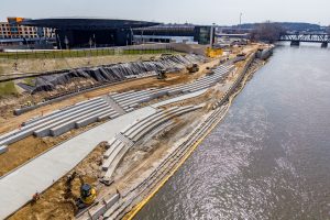 Aerial view of greenway construction along the Grand River with an amphitheater in the background